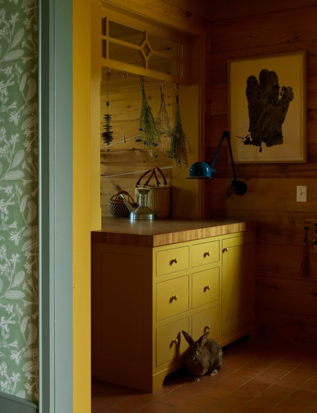 The utility room ended up being one of the most deliberated rooms in the home. With its location adjacent to the carport and front porch, it needed to serve a lot of functions while being a place for the family to enjoy. It would be a landing and launch pad, with storage and surfaces for all the daily gear, laundry, and an odd art or science project.

To break up the L-shaped space, we designed a partition to visually divide it into two more rectangular volumes. We added transom windows, implying that this room may have had a former life - perhaps the front porch had wrapped around the corner. Deep cabinetry below houses, amongst other things, a laundry cart and grocery totes. We specified a thick, hardy, end grain countertop from @armanifinewoodworking that will age beautifully with the home.

The wood paneling that wraps the room was originally going to be painted, like much of the wood throughout the house. However, when it started getting installed we all fell in love with it and decided to leave this room and the primary bath bare.

The paneling was also used to face some jib doors, hiding locker-like storage for coats, boots, and backpacks, and around the corner (not shown) the final destination for a laundry chute upstairs. We are on a personal mission to put more laundry chutes in homes!

In the laundry zone, our foreman Jim found this vintage concrete sink for us (!) after one we tried to get didn’t pan out. We designed a custom iron base for it that echoes some of the language in the steel structures outdoors, crafted for us by Bella Ironworks with precise coordination.

In the end, we think we hit the target - a utilitarian space that can host sports gear, rocks from the creek, and bunnies alike without worry of damage, while feeling cozy enough to want to pass some time.

The link to the feature is in our bio! 🏔️

Interior Architecture & Design: @landedinteriors #landedinteriors
Project Team: @heathermenegat, @rebeccamullerdesigns, Tiffany Kim, Luna Sibai, Laura Marx, Hanna Dooley
Architecture & Construction: @coburnpartners 
Landscape: @treeoflifelandscaping 
Photography: @yoshihiromakino 
Styling: @rainakattelson 
Publication: @archdigest